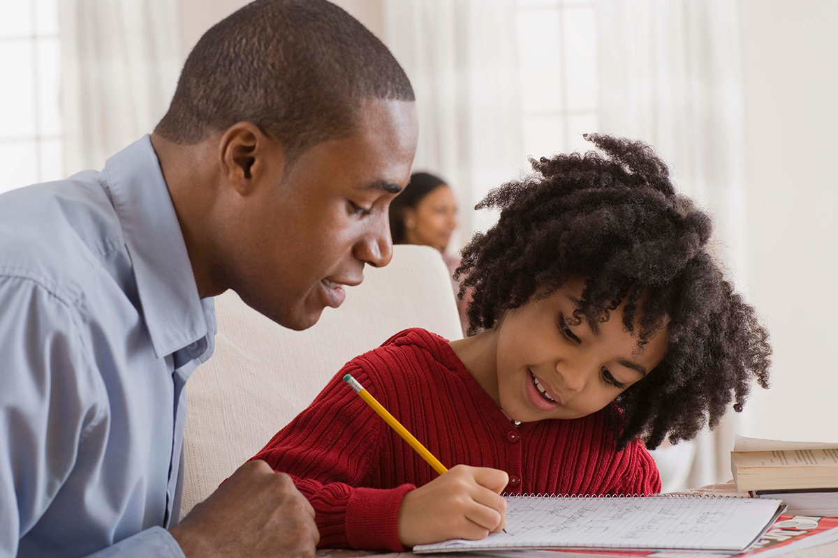 a father helping his young daughter with her homework